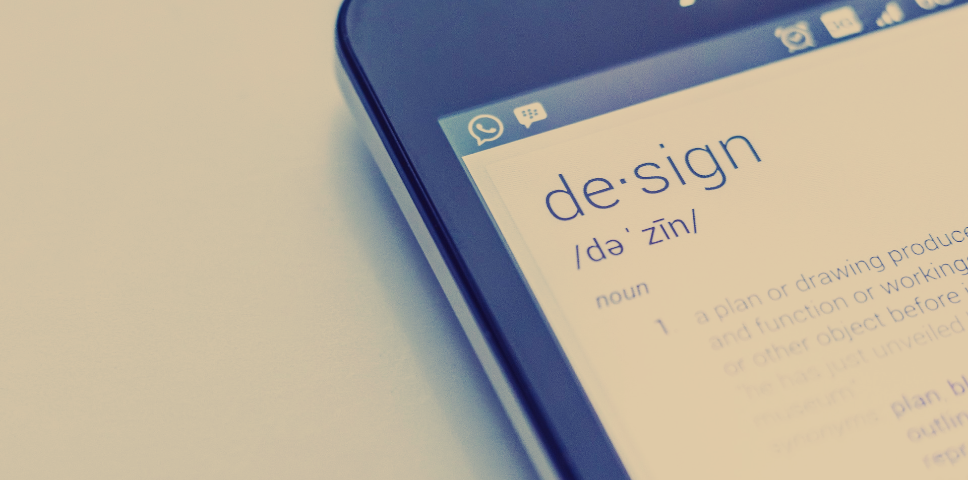 A close up of a cell phone with the word design on the screen.