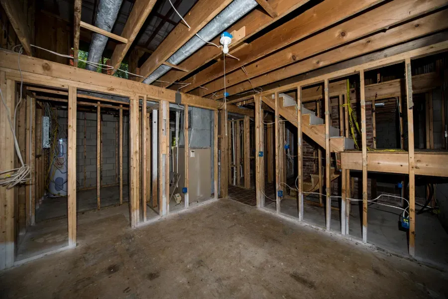 An empty basement with wooden walls and a staircase.