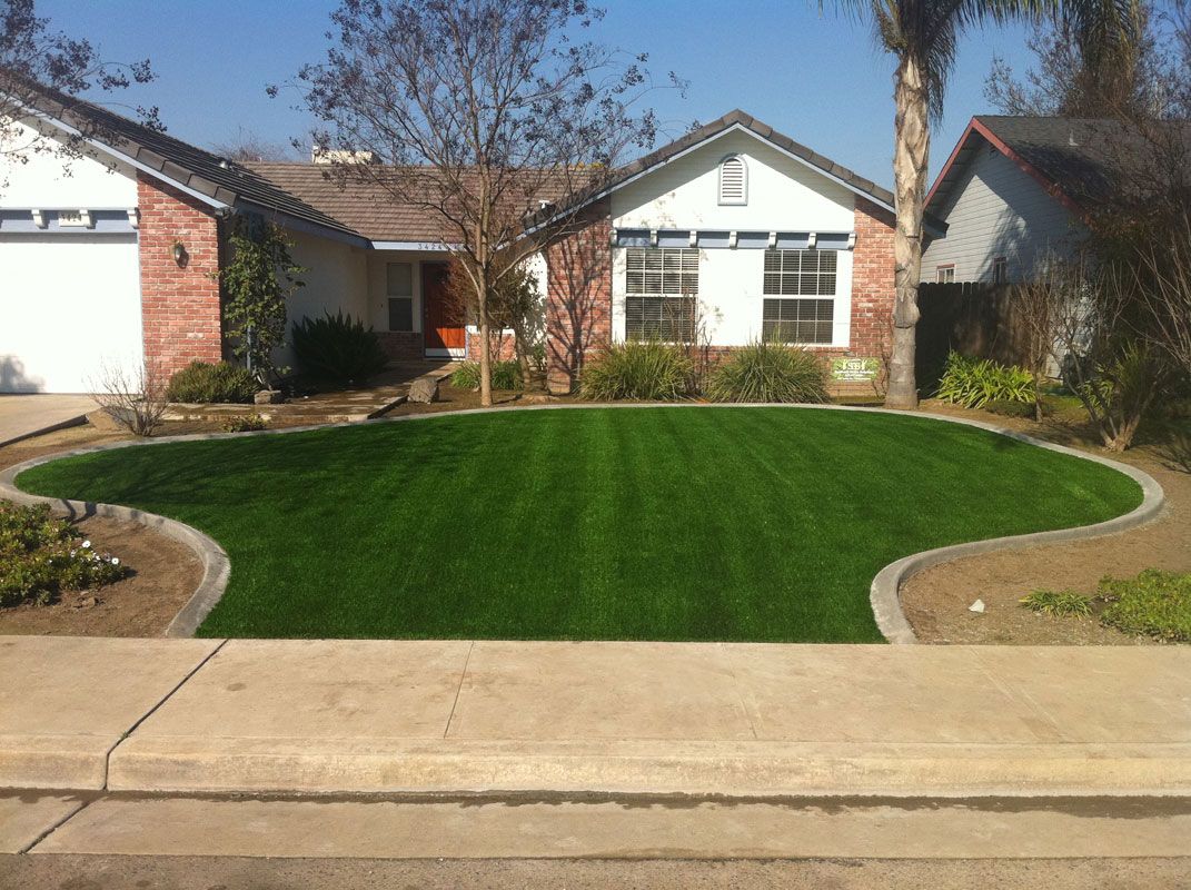 Suburban home with a freshly landscaped green front lawn and curved stone edging