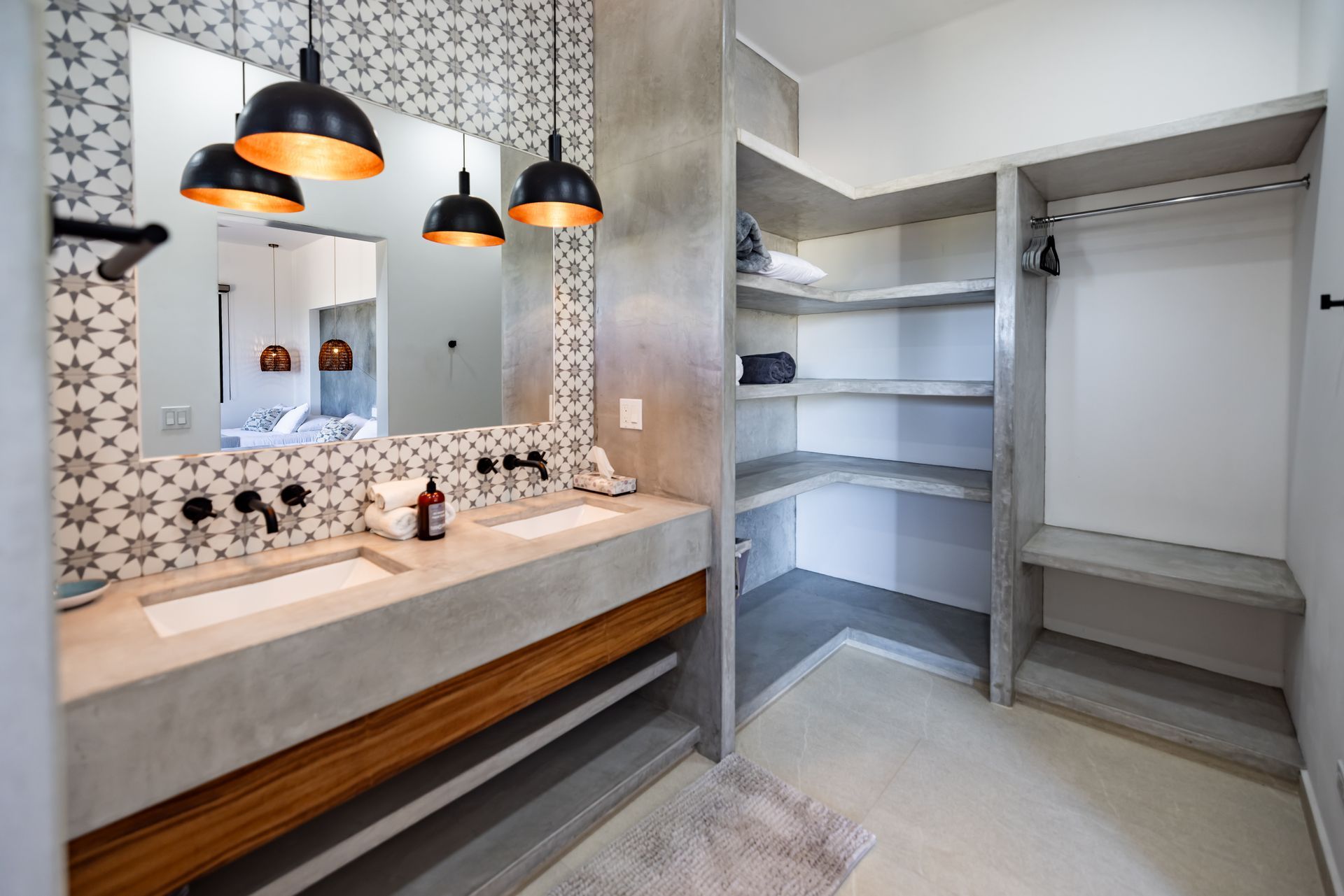 Bathroom with double sinks, decorative tile wall, and walk-in closet with shelves and hanging rod.