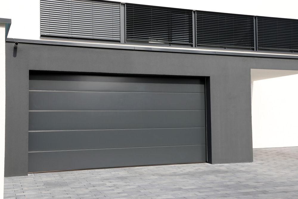 A gray garage door is on the side of a building — Gold Coast Door Centre In Burleigh Heads, QLD