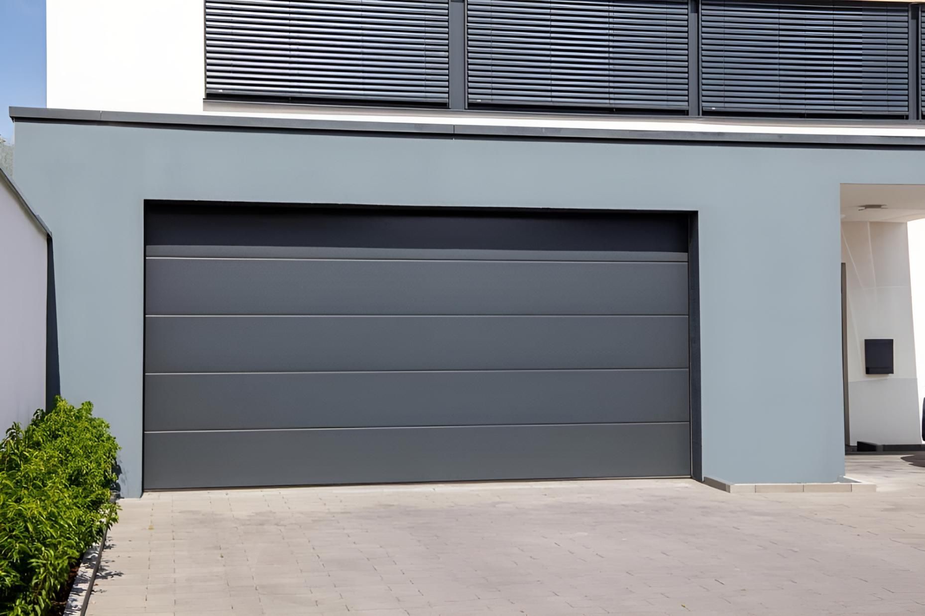 A Gray Garage Door Is In Front Of A House — Gold Coast Door Centre In Burleigh Heads, QLD