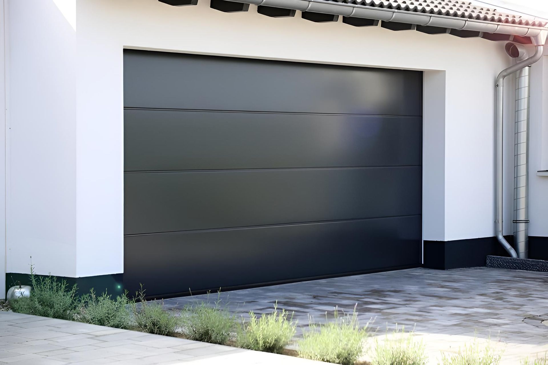 A Black Garage Door Is Sitting In Front Of A White House — Gold Coast Door Centre In Burleigh Heads, QLD