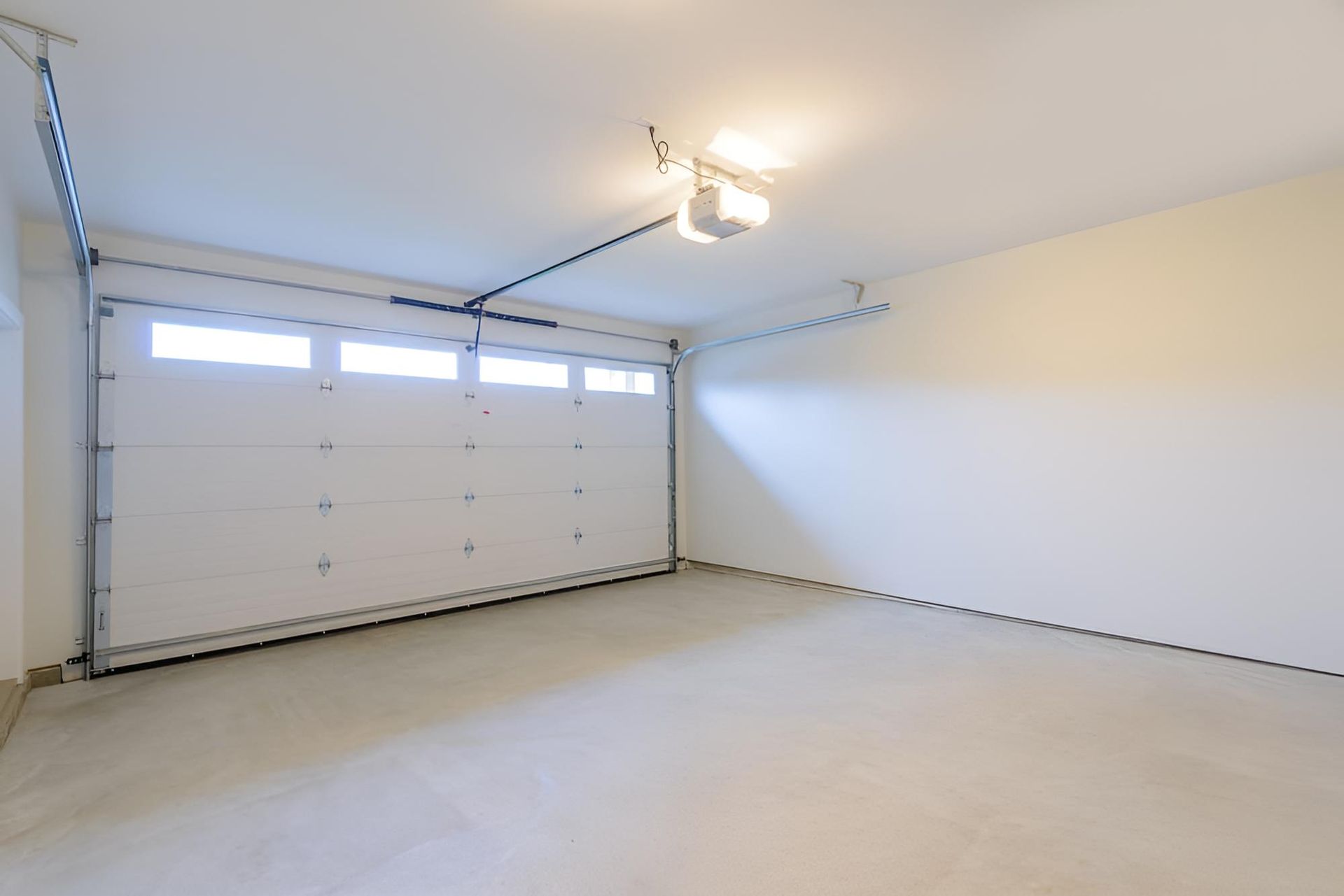 An Empty Garage With A Garage Door Open And A Light On The Ceiling — Gold Coast Door Centre In Burleigh Heads, QLD