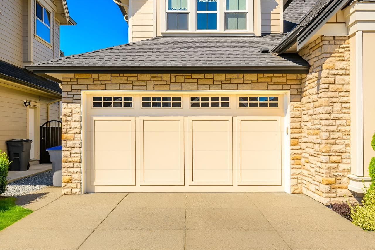 A Large White Garage Door Is Sitting In Front Of A Large House — Gold Coast Door Centre In Burleigh Heads, QLD