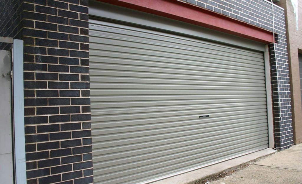 A Garage Door With A Brick Wall Behind It — Gold Coast Door Centre In Burleigh Heads, QLD