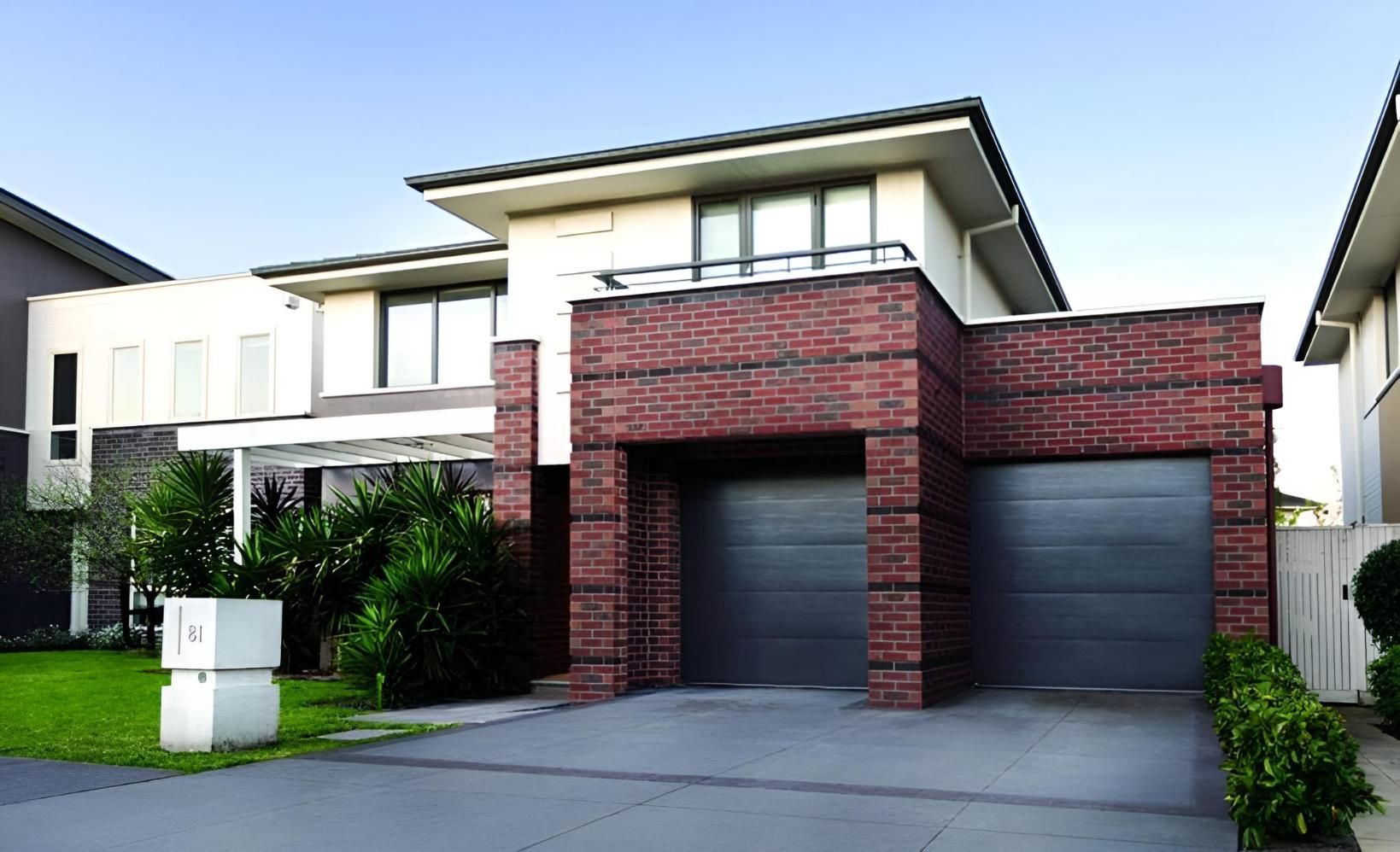 A Large Brick House With A Black Garage Door — Gold Coast Door Centre In Burleigh Heads, QLD