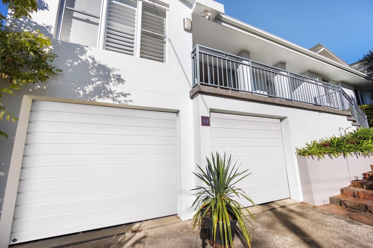 A White House With Two Garage Doors And A Balcony — Gold Coast Door Centre In Burleigh Heads, QLD