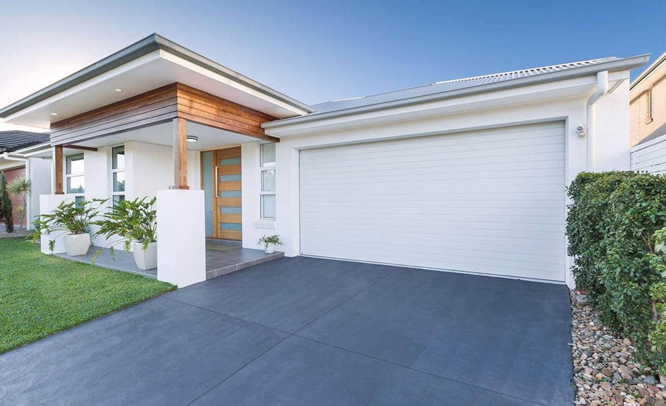 A White House With A Black Driveway And A White Garage Door — Gold Coast Door Centre In Burleigh Heads, QLD