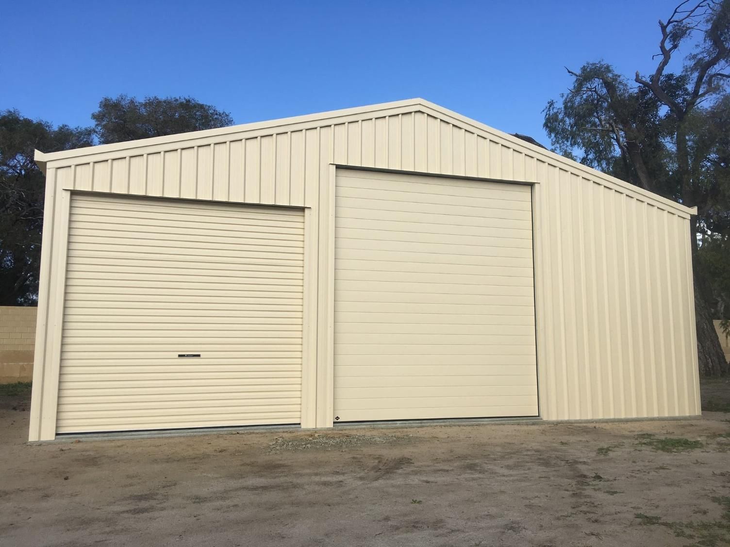 A White Garage With Two Garage Doors And A Blue Sky In The Background — Gold Coast Door Centre In Burleigh Heads, QLD