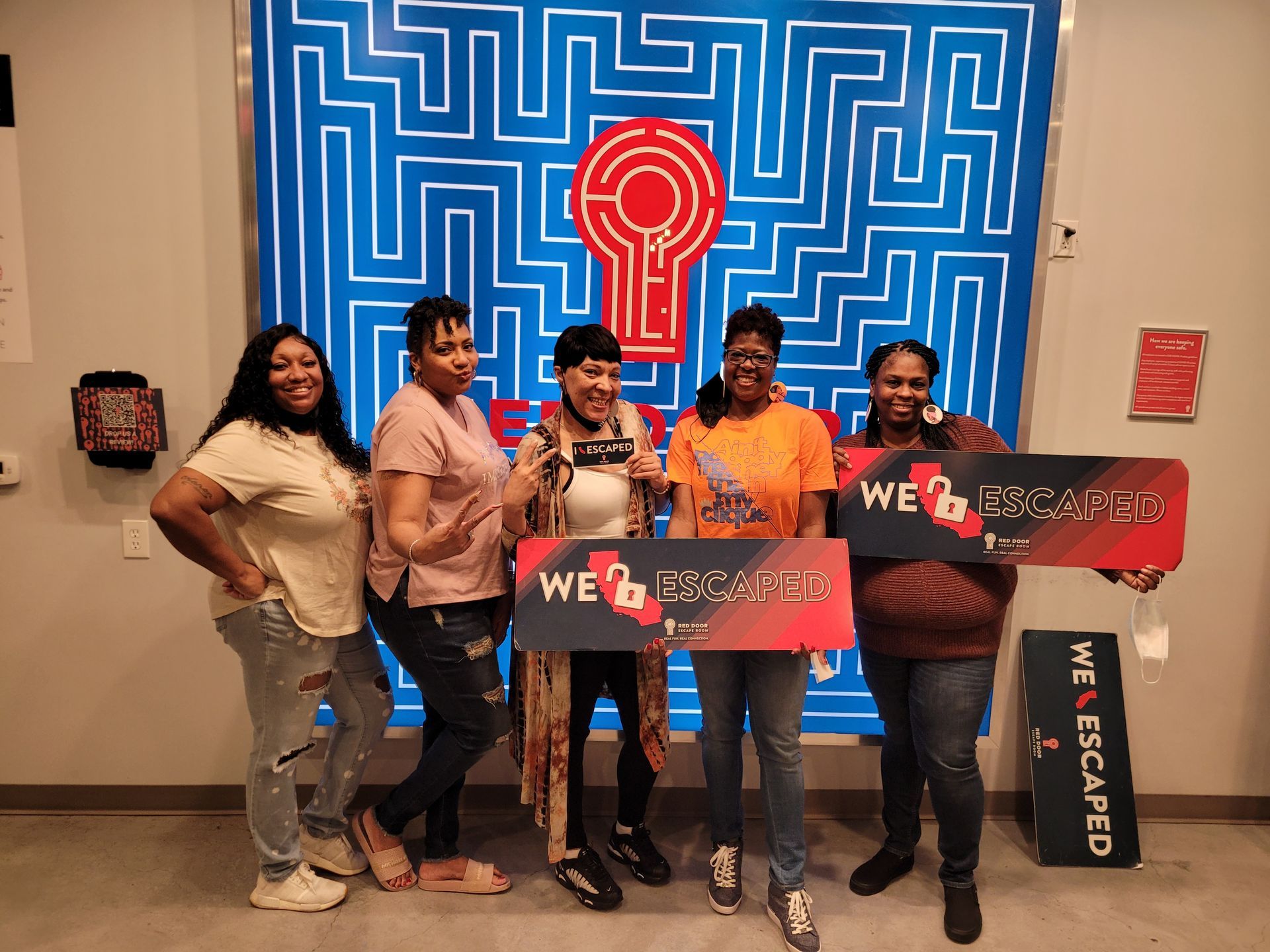 A group of women are posing for a picture in front of a maze.