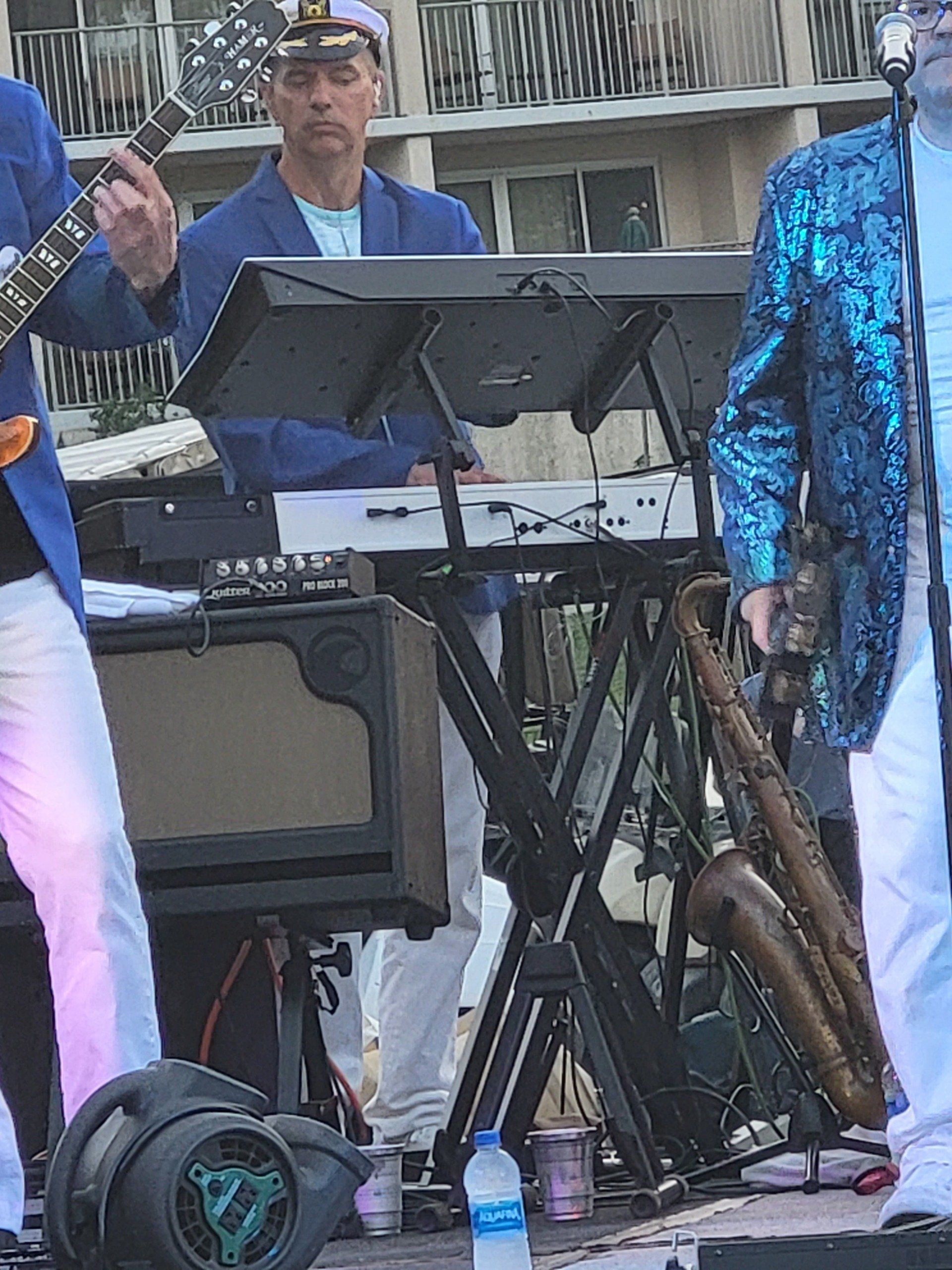 A man is playing a guitar and a man is playing a keyboard.