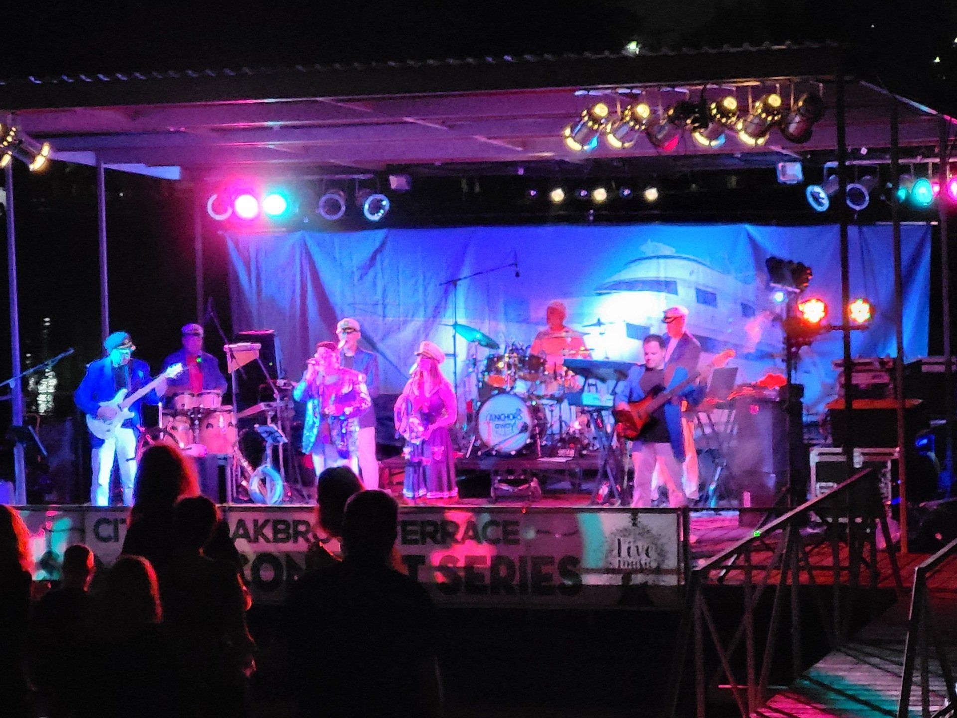 A group of people playing instruments on a stage in front of a sign that says terrace series