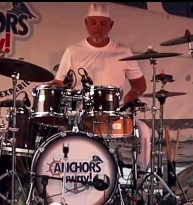 A man is playing drums at an anchors party