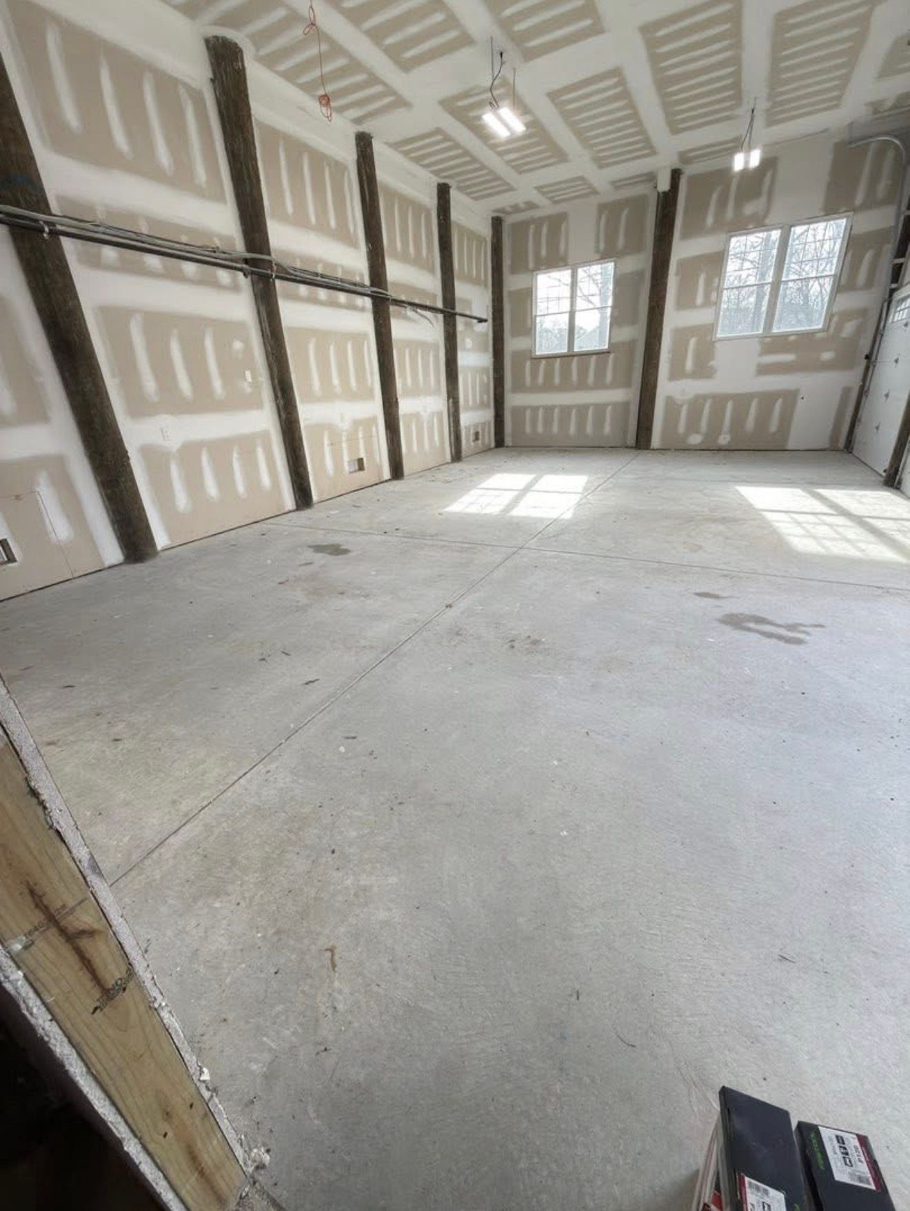 Empty room under construction with drywall and concrete floor.