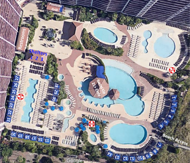Aerial view of a resort pool area with multiple blue pools, lounge chairs, umbrellas, and cabanas.