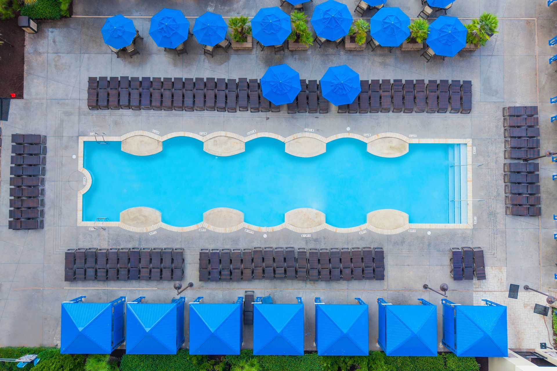 Martini glass with lemon garnish by a bright blue swimming pool