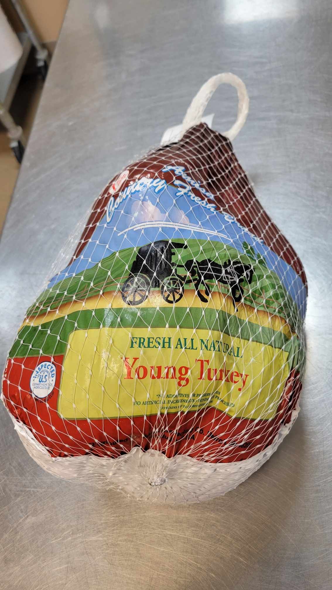 A turkey sitting on top of a stainless steel table.