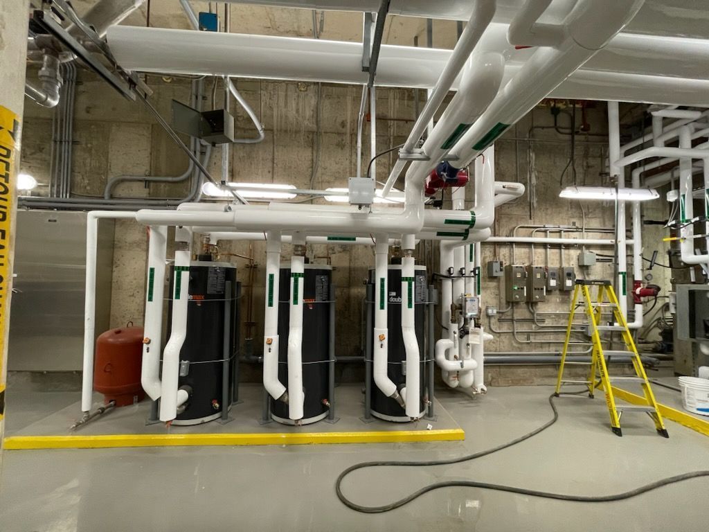 Une pièce avec beaucoup de tuyaux et une échelle à l'intérieur.