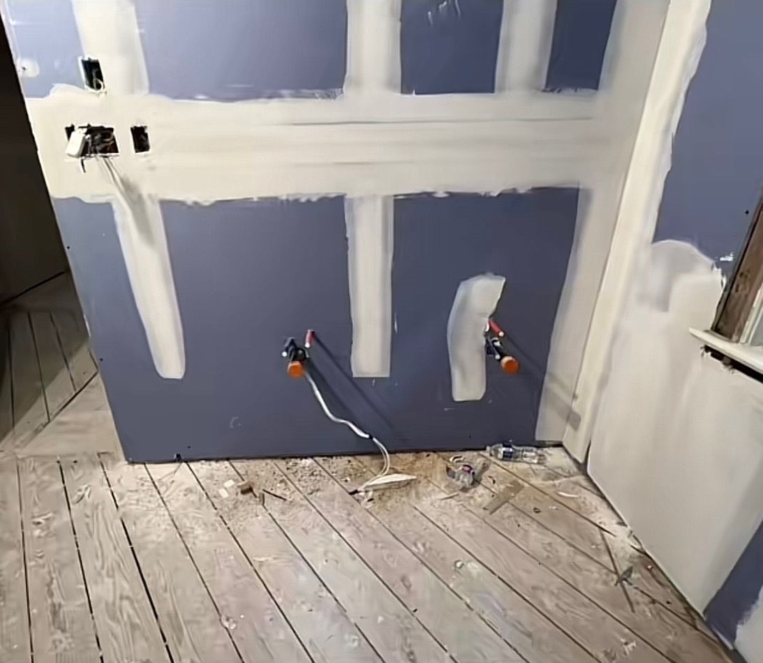 Un coin d'une pièce avec un mur bleu et un plancher en bois.