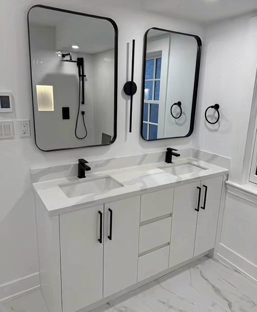 Une salle de bain avec deux lavabos et deux miroirs.