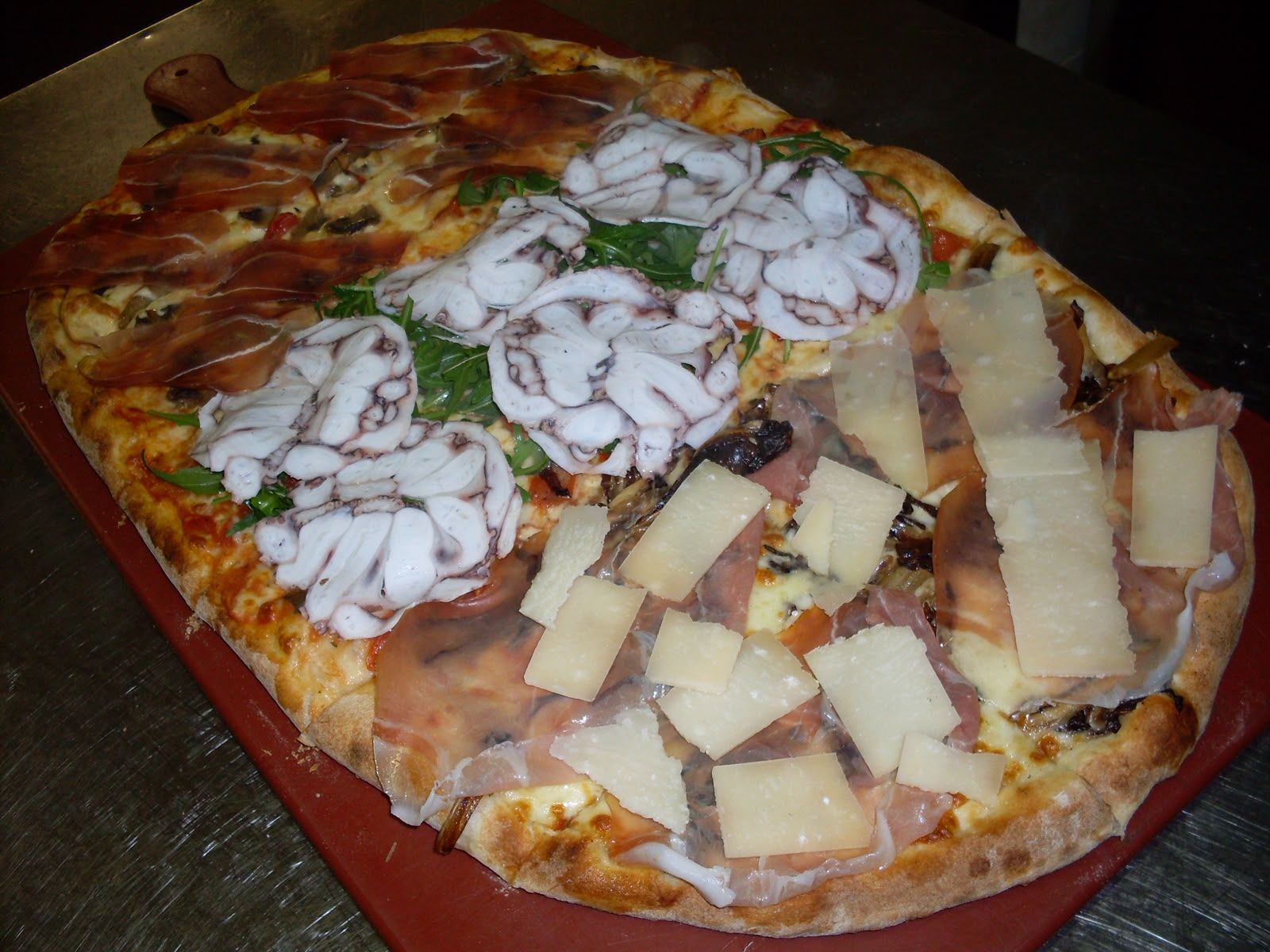 Fette di pizza assortite con condimenti bianchi e formaggio su un vassoio rosso