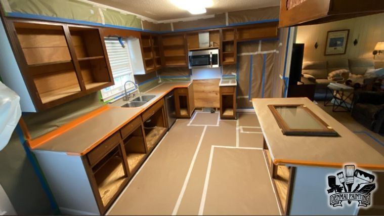 Empty RV kitchen with wood cabinets, tan countertops, and a white stove and microwave.