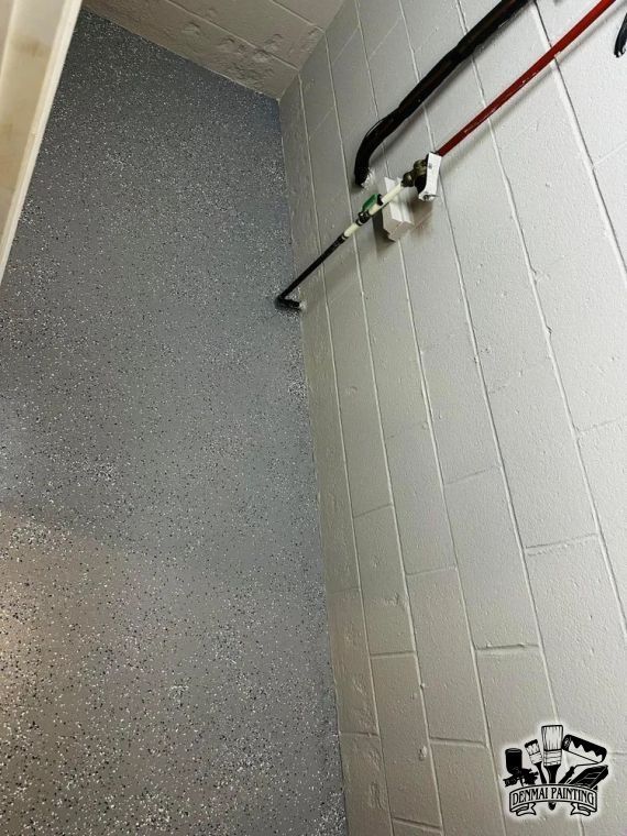 A tiled shower corner with a chrome grab bar and a showerhead on the wall.