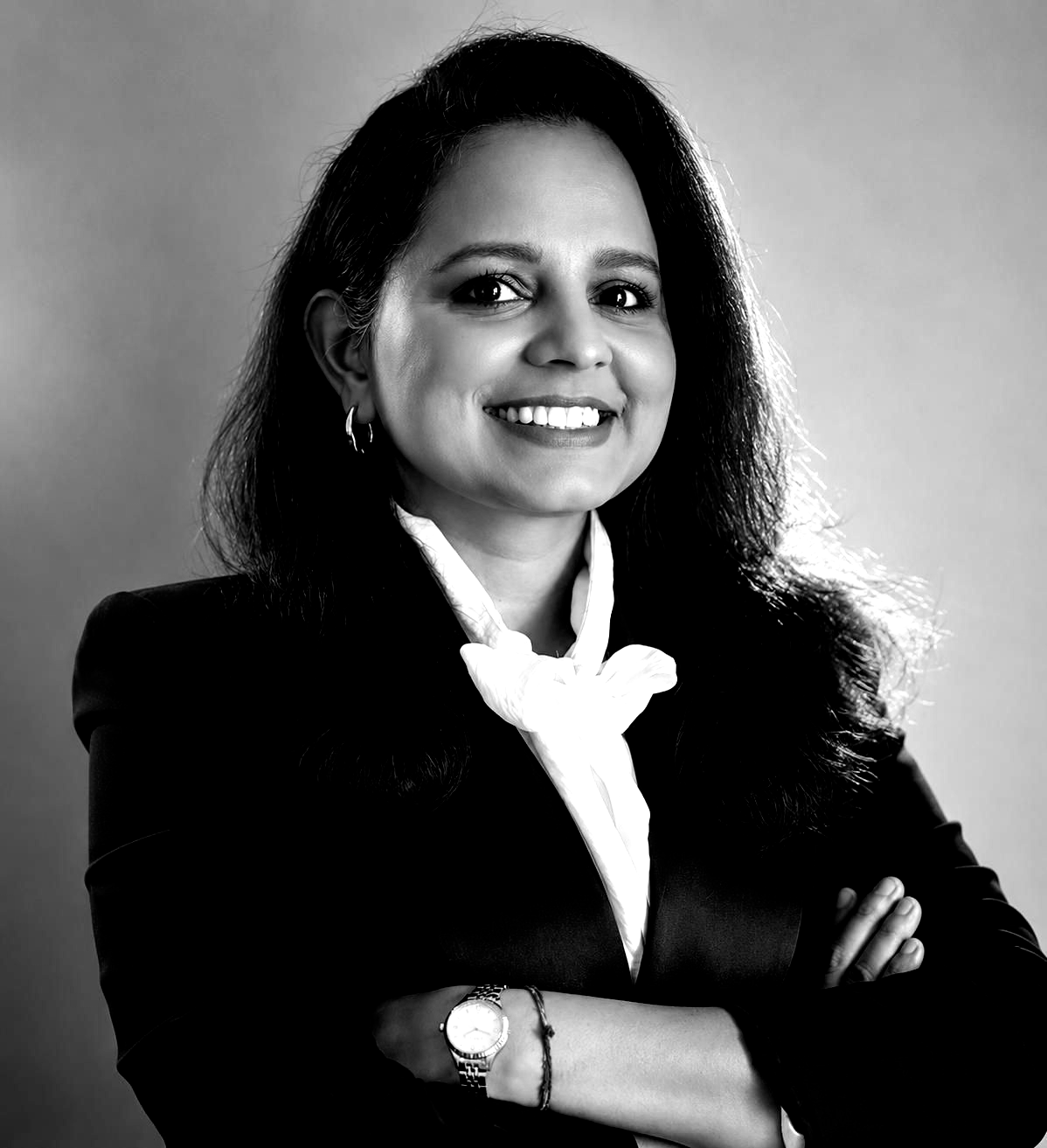 A woman with long hair and hoop earrings is smiling in a black and white photo.