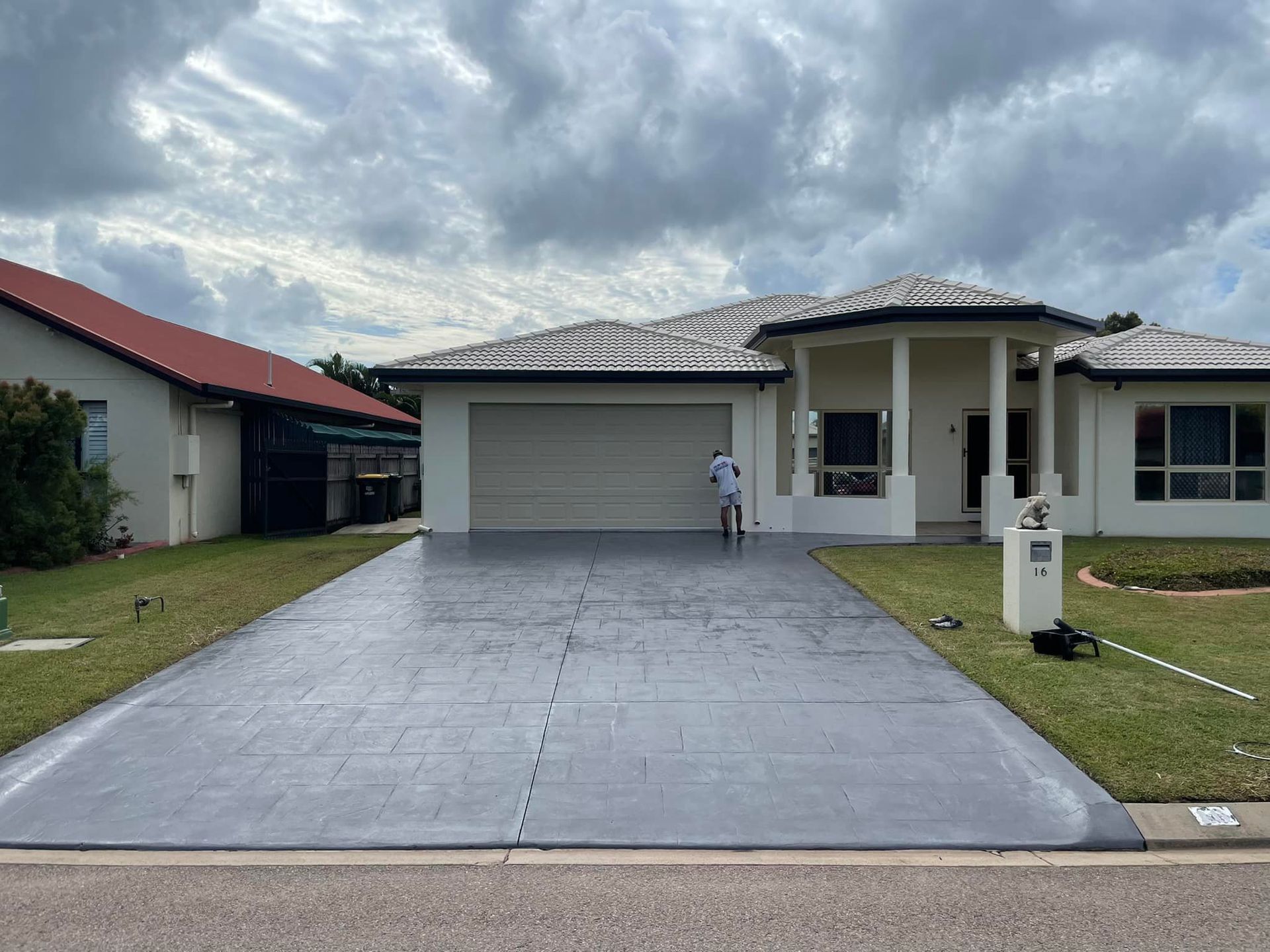 A Man Painting A House With A Driveway— Marteene Painting Services In Kirwan, QLD