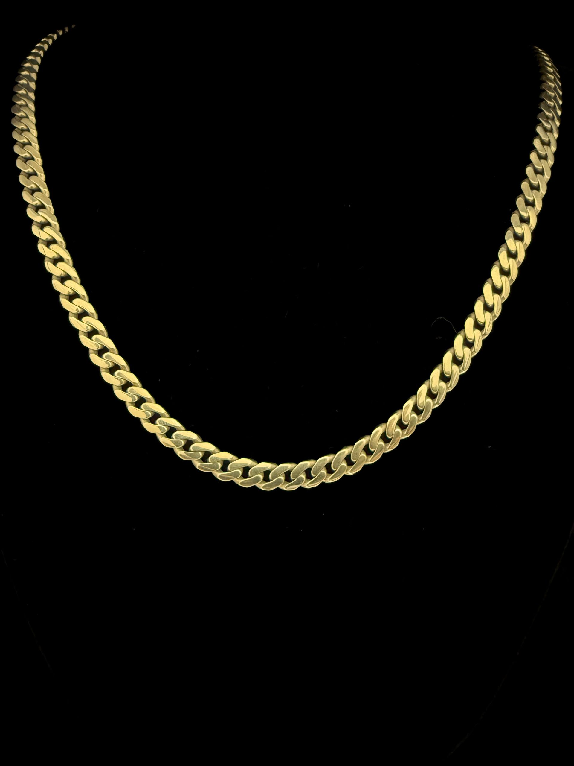 A close up of a gold chain on a black background