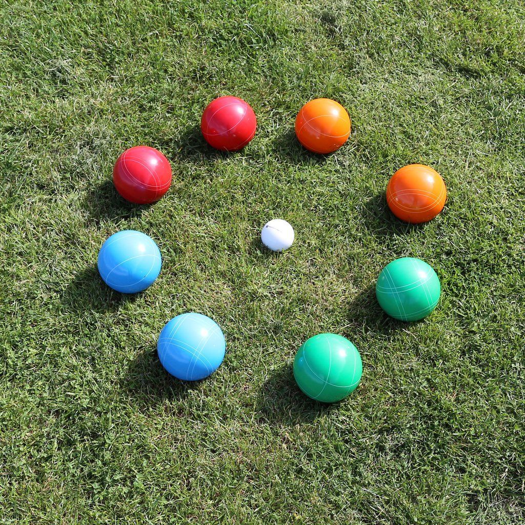 Colored bocce balls arranged on grass around a small white ball