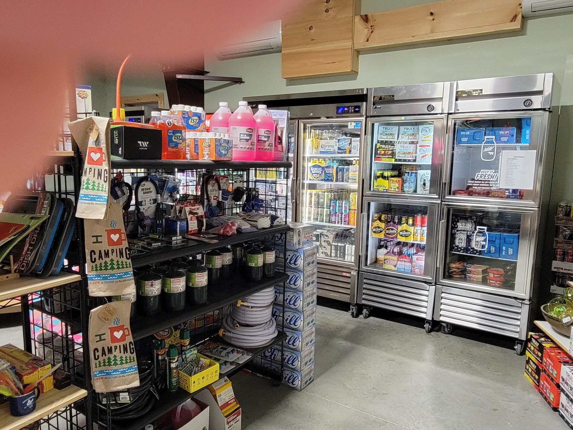 Convenience store aisle with refrigerated drinks, snacks, and candy displays