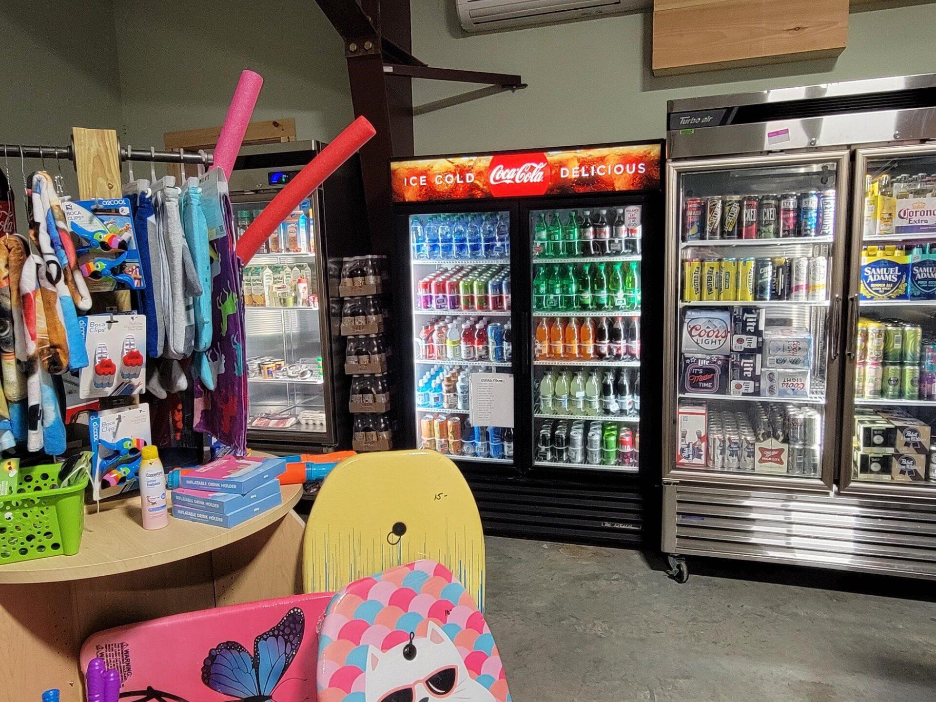Convenience store interior with beverage coolers, snacks, and colorful chair in the foreground