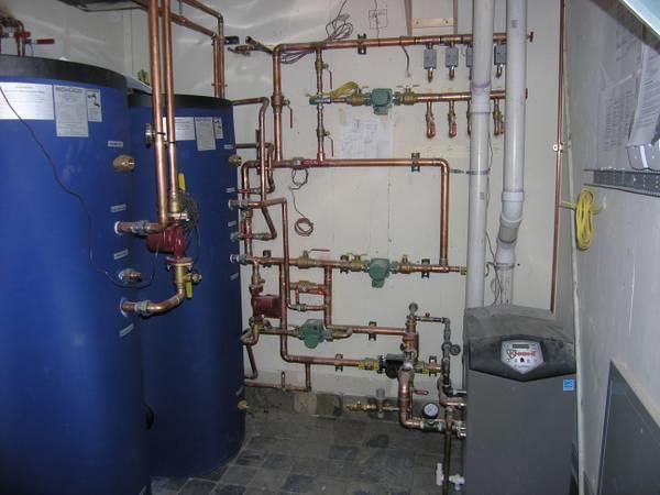Technician performing maintenance on a heating boiler, inspecting and servicing its components for optimal functionality.