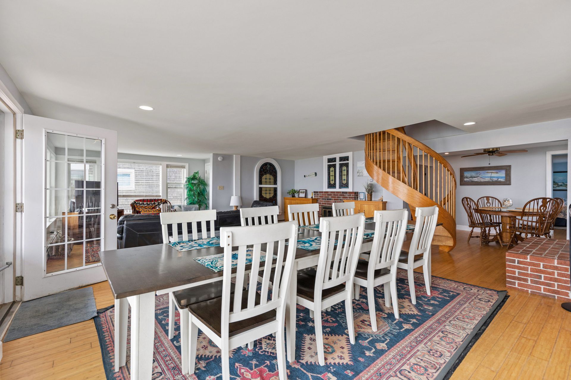 A large dining room with a table and chairs and a rug.