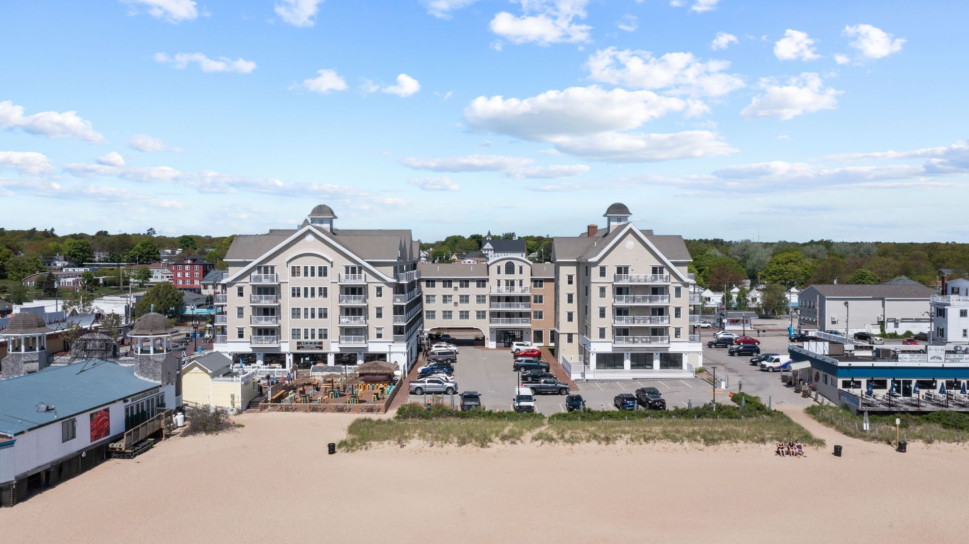 An aerial view of a large building sitting on top of a sandy beach.