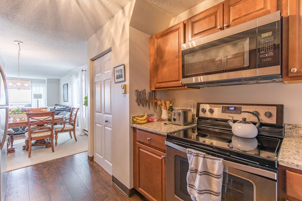 A kitchen with stainless steel appliances and wooden cabinets.
