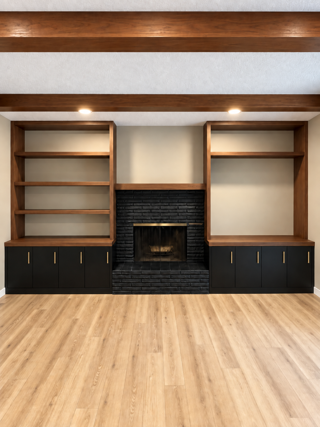 Built-in wooden shelves and cabinets flanking a black brick fireplace in a bright room
