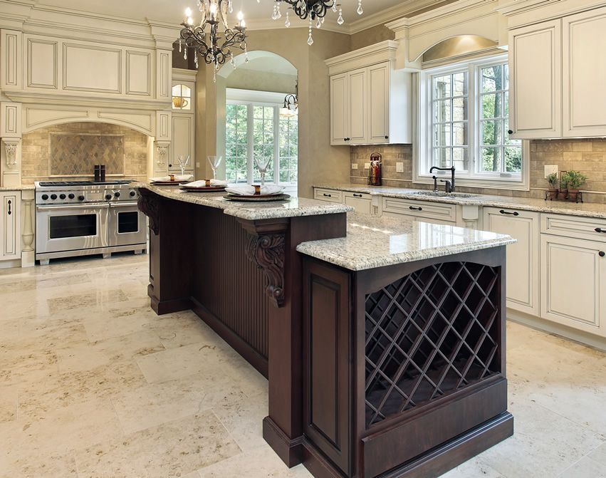 Luxurious kitchen with a dark wood island, granite countertops, and white cabinets.