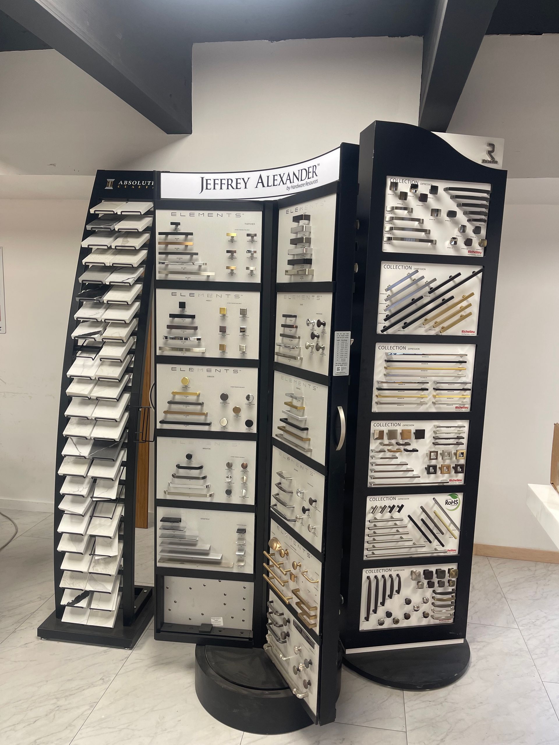 Display stand showcasing various hardware products. Black and white with metal and wood fixtures.
