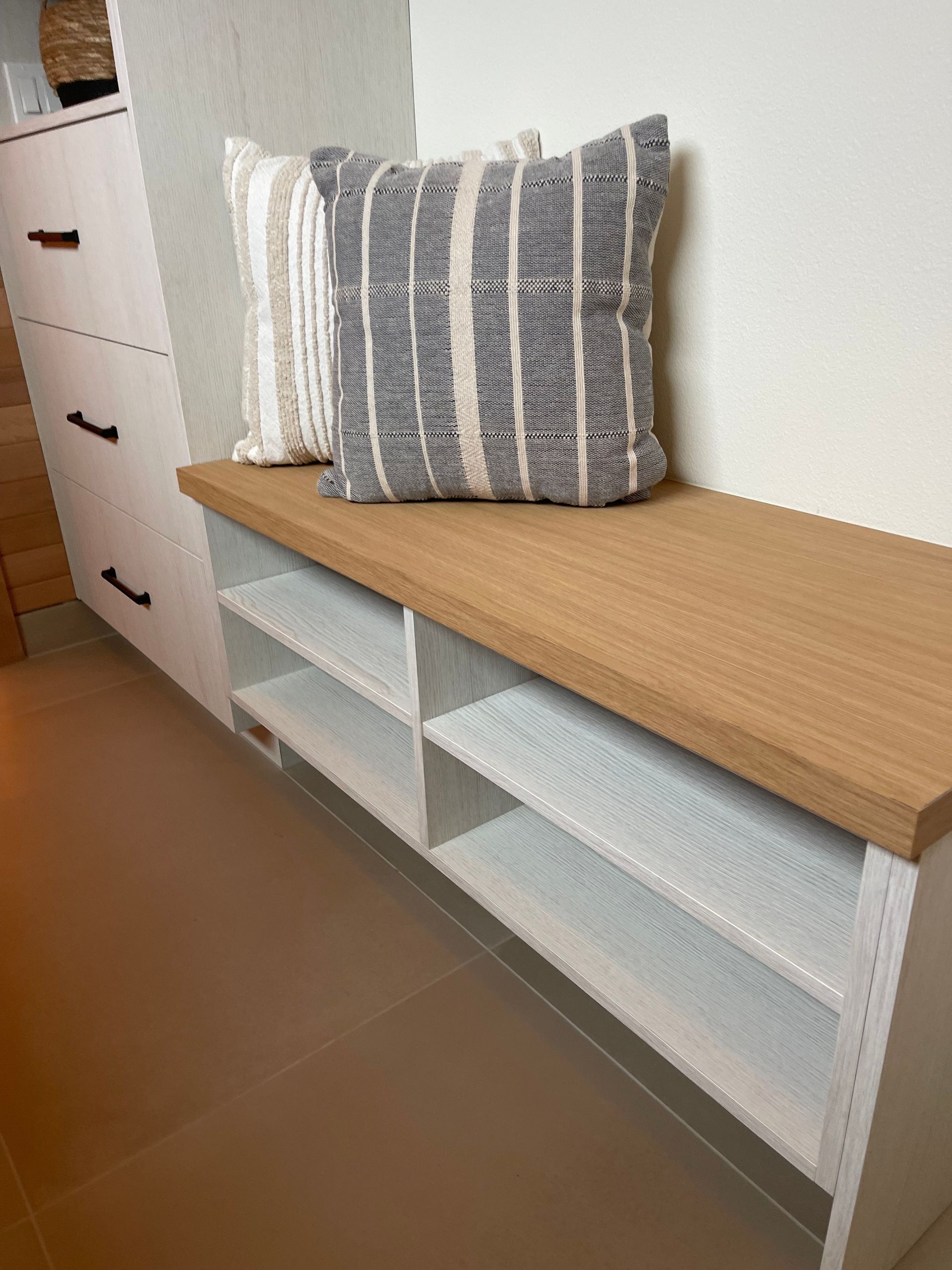 A wooden-topped white shoe bench with two shelves. Pro-tech woodworking in Portland