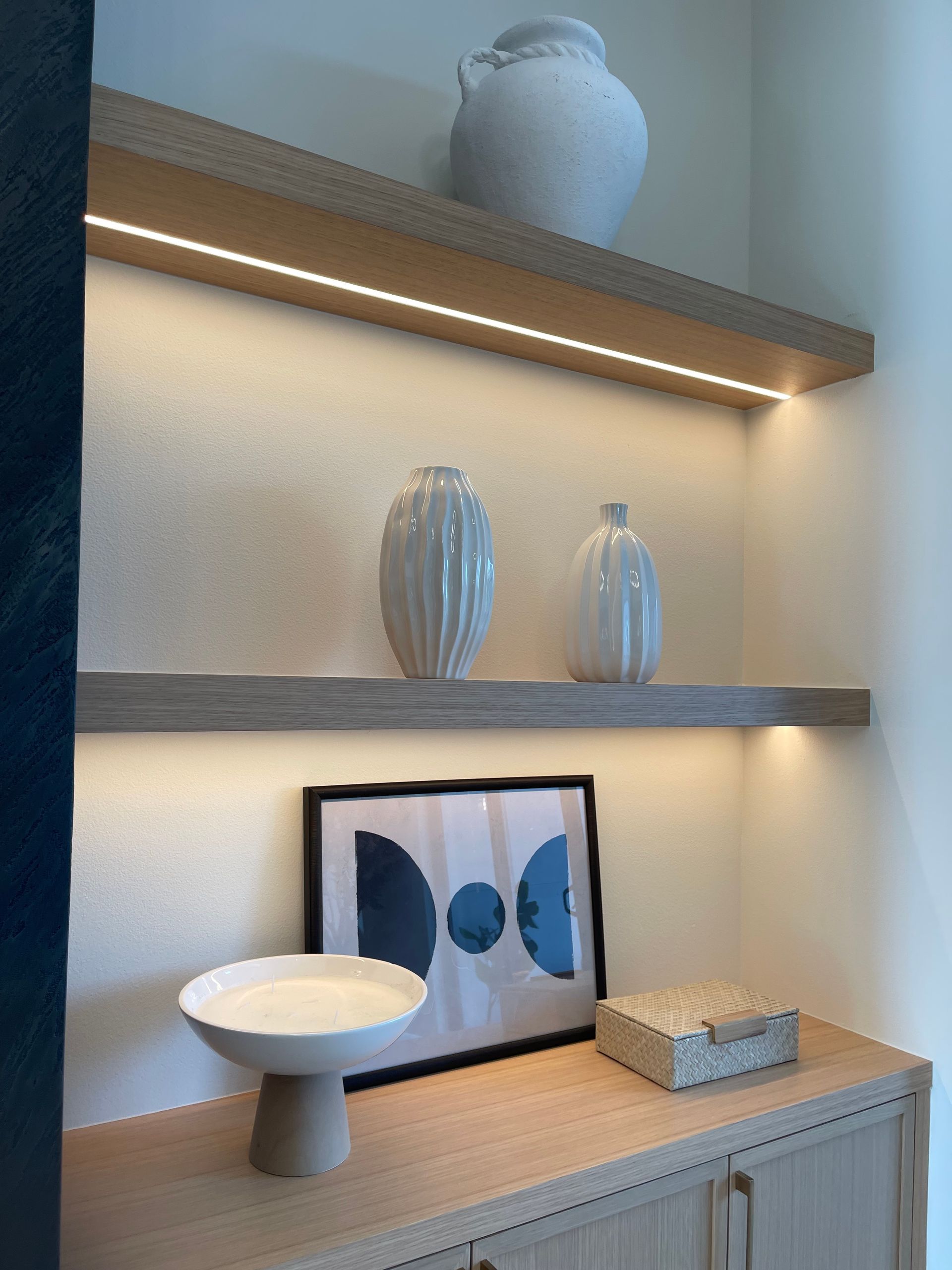 Decorative shelves with white and blue ceramics, and a bowl under warm lighting in Portland, from Pro-techwoodworkig
