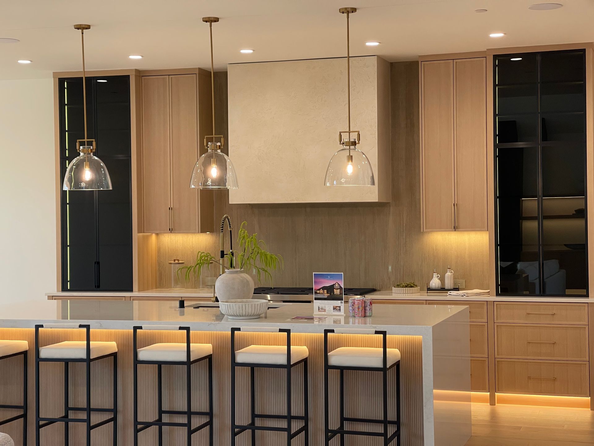 Modern kitchen with island seating, pendant lights, and warm under-cabinet lighting