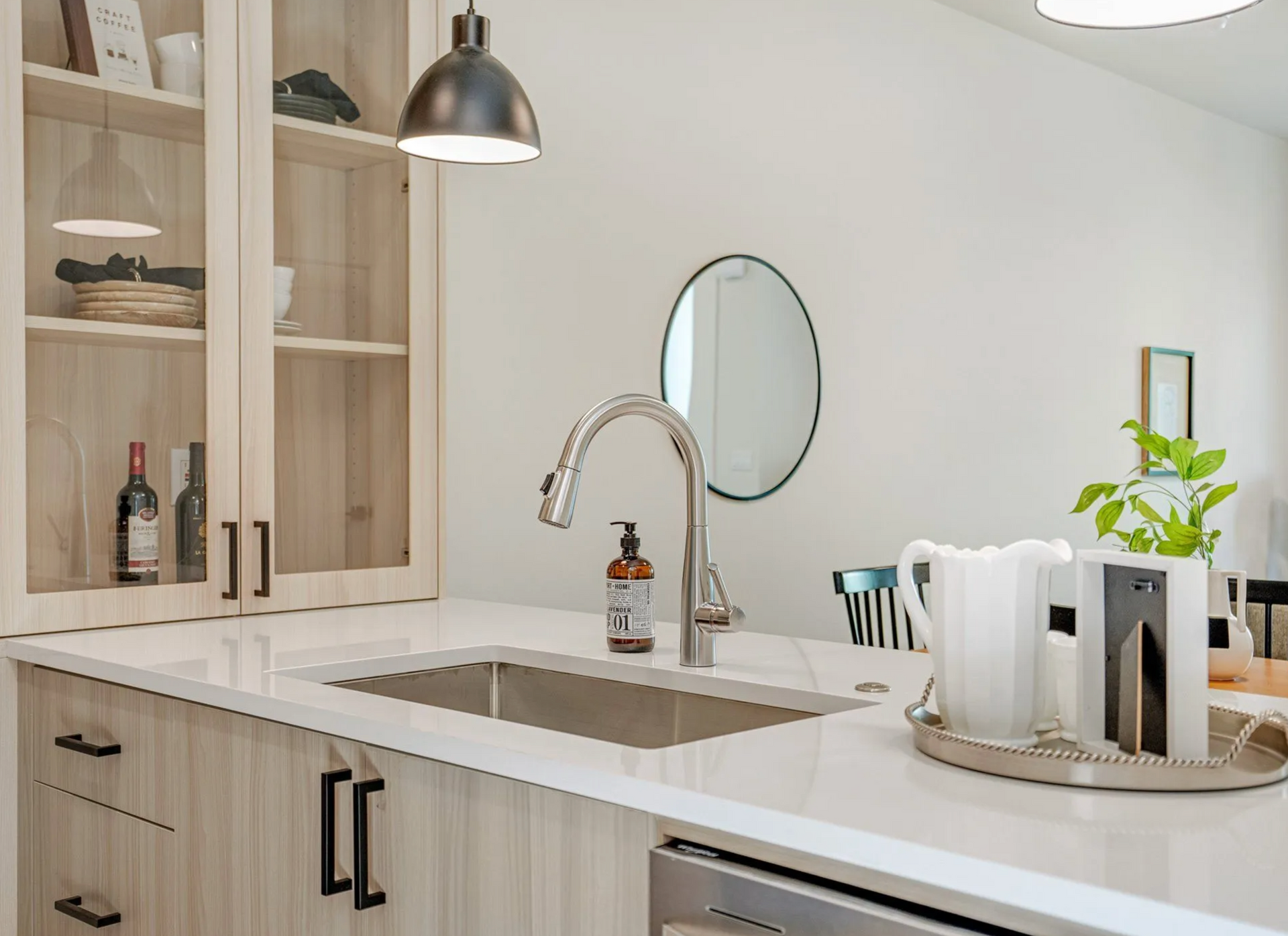 Light vanities with white shaker cabinets, open shelves, and natural decor in Portland