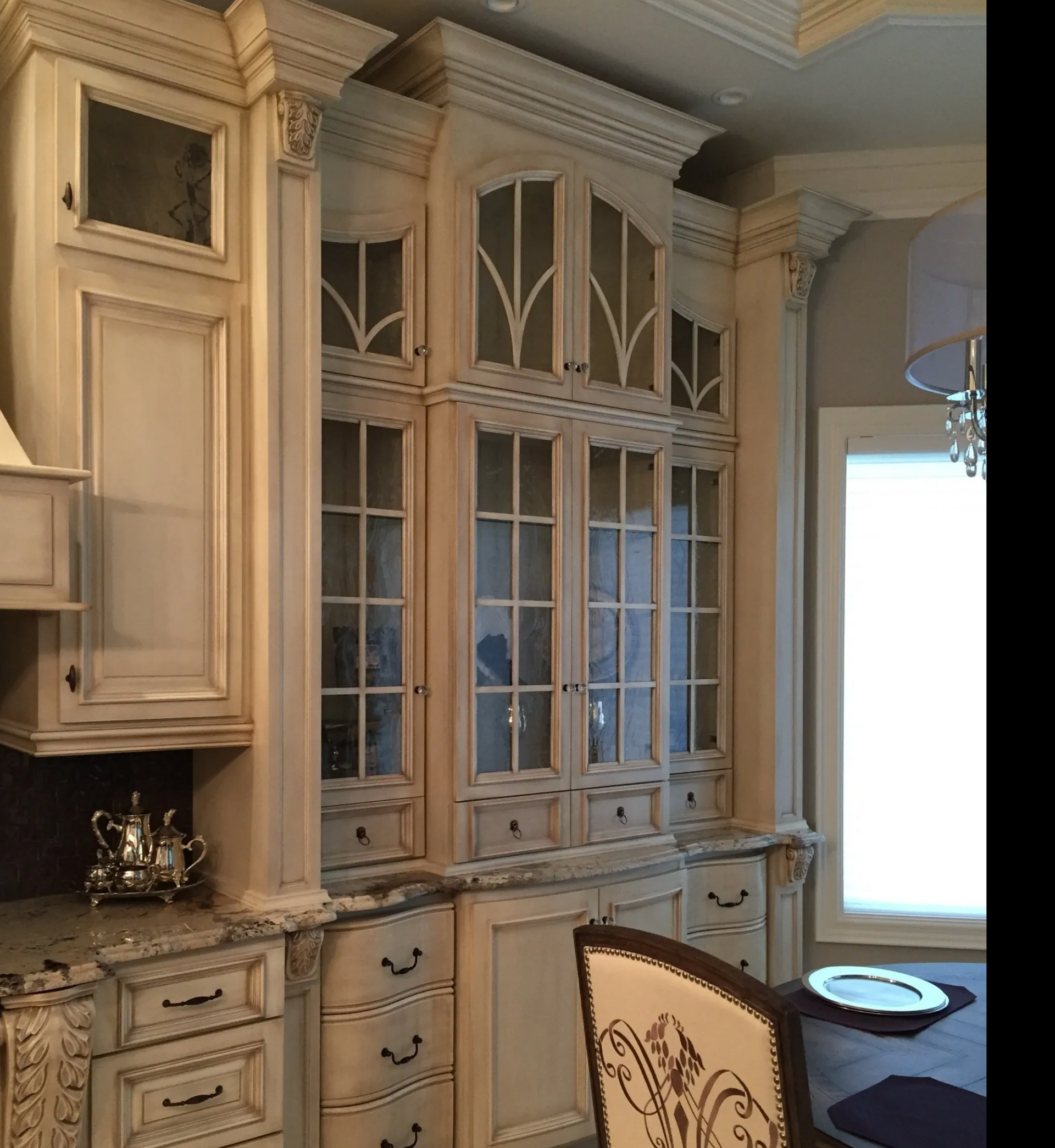 Upper cabinets with glass doors and crown molding in classic kitchen design in Hillsboro