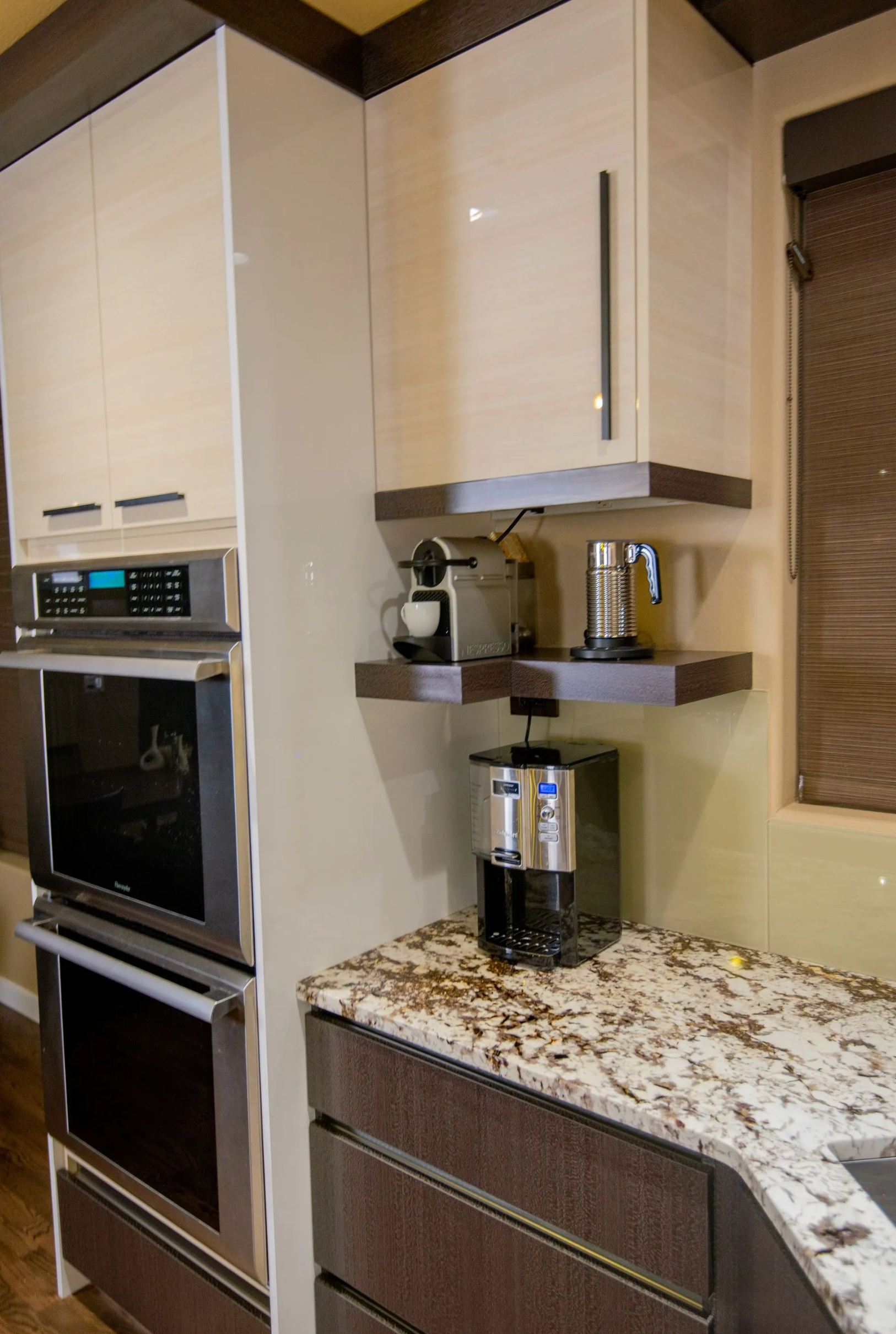 Dark wood kitchen island and white upper cabinets in contemporary layout in Portland