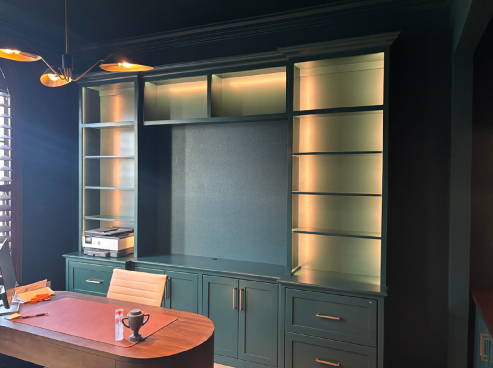 Built-in wooden wall unit with shelves and cabinets in a dining room