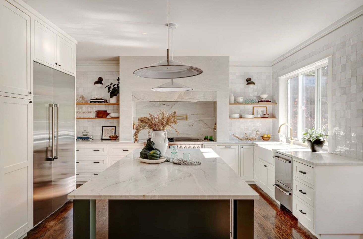 Bright white kitchen with island, open shelving, and pendant lighting