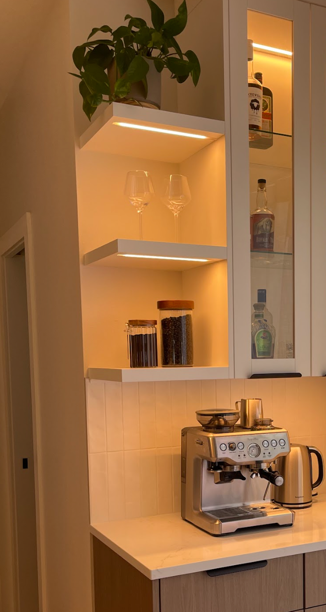 Modern kitchen nook with floating shelves, warm under-cabinet lighting in Portland, from Pro-techwoodworkig